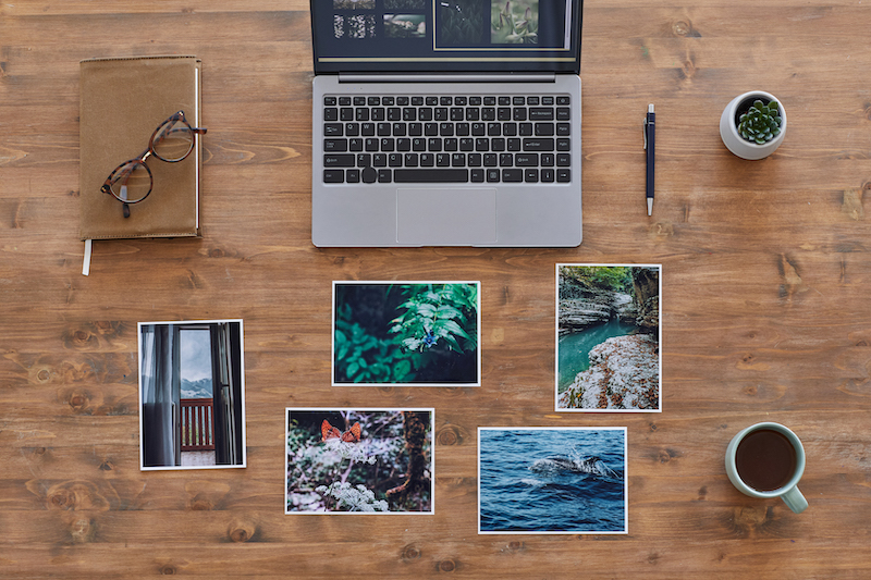 Photo of laptop and photographs on a desk