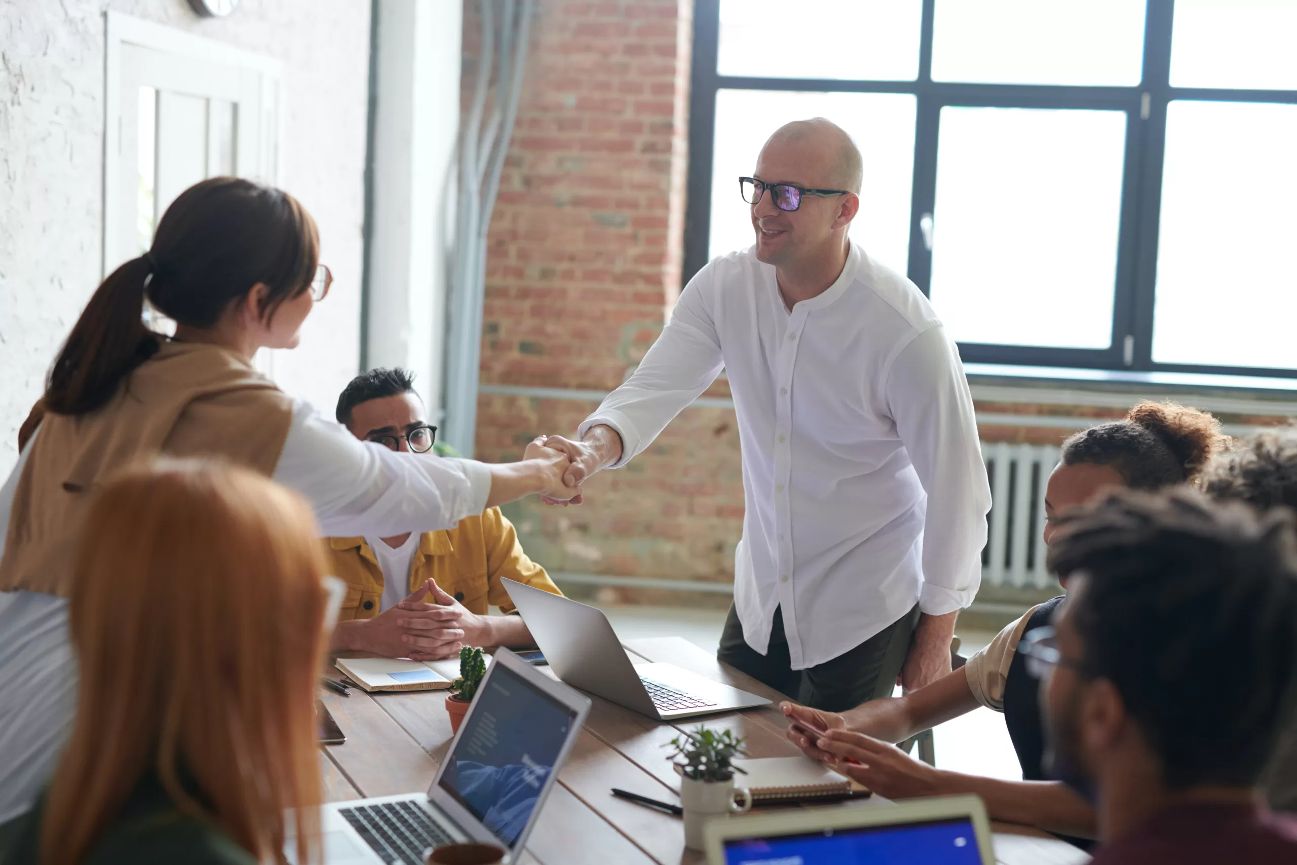 Man and woman shaking hands in a professional setting.