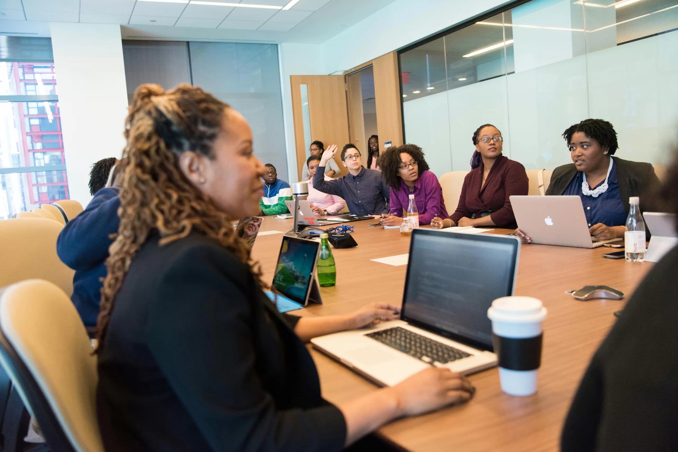Photo of boardroom with many people sitting at a table.
